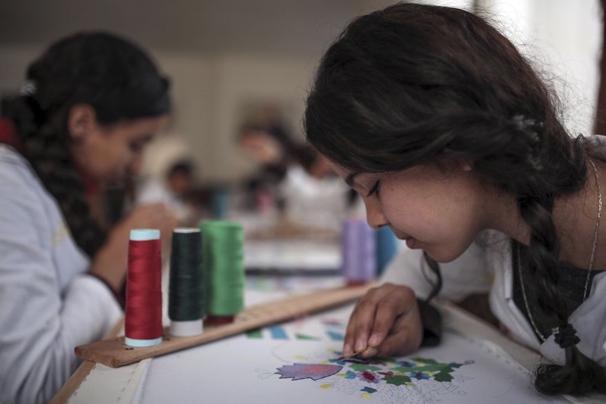 In this photo dated Tuesday, Feb. 28, 2017, children learn embroidery in an informal school run by Moroccan fashion designer Fadila El Gadi, in Sale, near Rabat, Morocco. A globally successful Moroccan fashion designer returned to her hometown and founded an unusual sewing school aimed at helping poor, troubled children find a path, in a country where youth unemployment is high and the lure of extremism lurks. (AP Photo/Mosa'ab Elshamy)