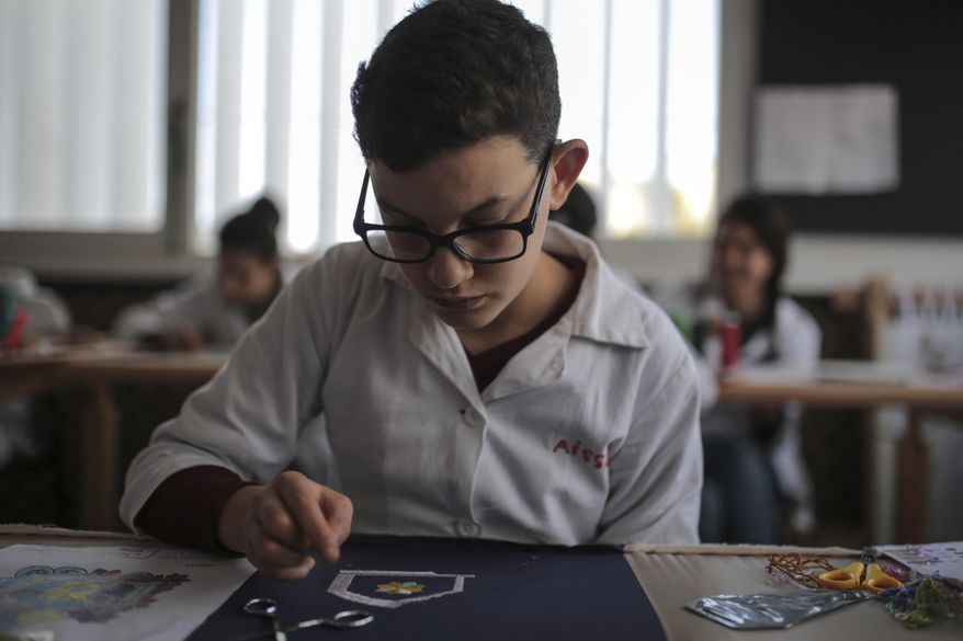 In this photo dated Tuesday, Feb. 28, 2017, a child learns embroidery in an informal school run by Moroccan fashion designer Fadila El Gadi, in Sale, near Rabat, Morocco. A globally successful Moroccan fashion designer returned to her hometown and founded an unusual sewing school aimed at helping poor, troubled children find a path, in a country where youth unemployment is high and the lure of extremism lurks. (AP Photo/Mosa'ab Elshamy)