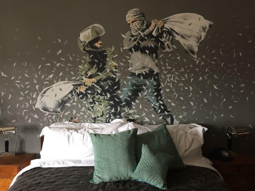 A bedroom in a new guesthouse shows artwork by Banksy in the West Bank city of Bethlehem on Friday. Mar. 3, 2017. The owner says he is putting the finishing touches to the "hotel with the worst view in the world." The nine-room hotel named "The Walled Off Hotel" will officially open on Mar. 11. (AP Photo/Dusan Vranic)