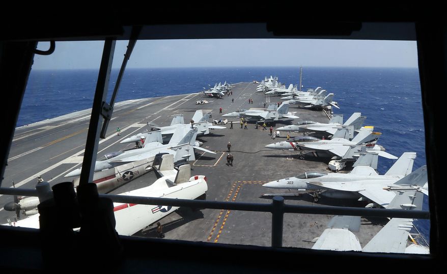 Fighter jets on board the U.S. Navy aircraft carrier USS Carl Vinson (CVN 70) are prepared for patrols off the disputed South China Sea Friday, March 3, 2017. The U.S. military took journalists Friday to a mammoth aircraft carrier on routine patrol off the disputed South China Sea, sending a signal to China and American allies of its resolve to ensure freedom of navigation and overflight in one of the world's security hotspots.(AP Photo/Bullit Marquez)