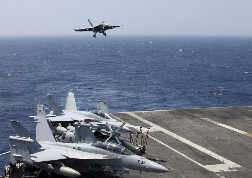 A U.S. Navy F18 fighter jet lands on the U.S. Navy aircraft carrier USS Carl Vinson (CVN 70) following a patrol off the disputed South China Sea Friday, March 3, 2017. The US military took journalists Friday to a mammoth aircraft carrier on routine patrol off the disputed South China Sea, sending a signal to China and American allies of its resolve to ensure freedom of navigation and overflight in one of the world's security hotspots.(AP Photo/Bullit Marquez)