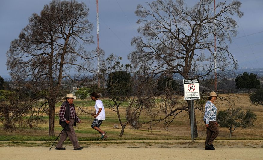 FILE - In this Aug. 12, 2016 file photo, early morning hikers walk along a path at the Kenneth Hahn State Recreation Area in Los Angeles. A long-term plan for cleaning up the air in a huge swath of smoggy Southern California is due for consideration by regulators. Directors of the South Coast Air Quality Management District are expected to vote on the plan Friday, March 3, 2017. (AP Photo/Richard Vogel, File)
