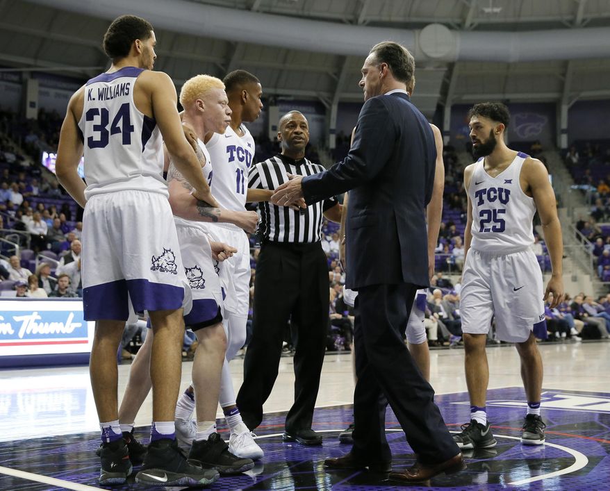 In this March 1, 2017 photo, TCU's Kenrich Williams (34), Jaylen Fisher (0), Brandon Parrish (11) and Alex Robinson (25) talk with an official and head coach Jamie Dixon, center right, after a foul call during an NCAA college basketball game against Kansas State in Fort Worth, Texas. A week into February, TCU had just pulled out a one-point victory at home and had already won six Big 12 games under new coach Jamie Dixon. (AP Photo/Tony Gutierrez)