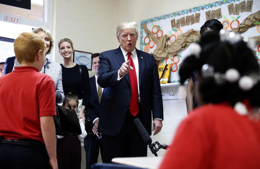 President Donald Trump talks to children in Jane Jones fourth grade class during a tour of Saint Andrew Catholic School, Friday, March 3, 2017, in Orlando, Fla. At left is Trump's daughter Ivanka Trump. (AP Photo/Alex Brandon)