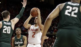 Maryland guard Melo Trimble (2) shoots against Michigan State guards Matt McQuaid (20), Cassius Winston (5) and Miles Bridges in the second half of an NCAA college basketball game, Saturday, March 4, 2017, in College Park, Md. Maryland won 63-60. (AP Photo/Patrick Semansky)