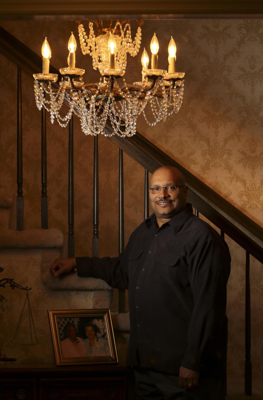 This photo taken Feb. 27, 2017, shows East Ridge, Tennessee, resident Andre Boaz posing with a portrait of his great-aunt Mary Jackson, left, and mother Aurellia Mitchell Boaz who were both featured in the recent movie "Hidden Figures". (Dan Henry/Chattanooga Times Free Press via AP)