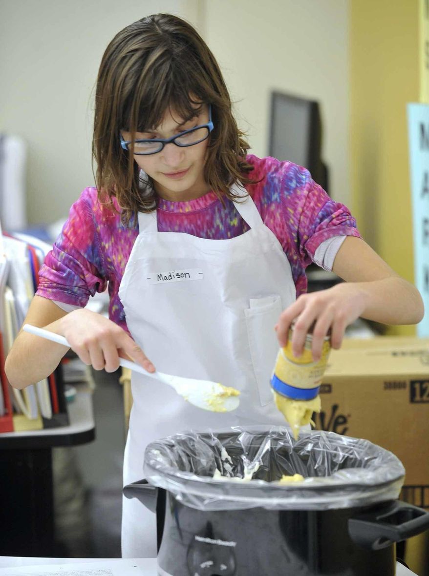In this Thursday, Jan. 19, 2017 photo, Madison Pommer, 10, adds a can of cream of chicken soup to a chicken enchilada dip she was making with other members of the Quick Fixin' Young Chefs Club at the Fort Dodge Middle School, in Iowa. The popular club gives students a chance to learn basic cooking skills. (Hans Madsen/The Messenger via AP)