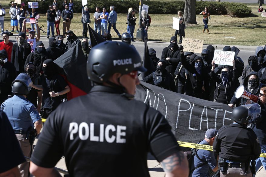 Anti-Trump protesters chant as police separate them from supporters of President Donald Trump gathered nearby during a March 4 Trump rally on the state Capitol steps in Denver, Saturday, March 4, 2017. (AP Photo/Brennan Linsley)