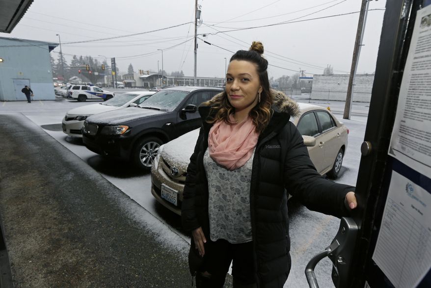 In this photo taken Feb. 27, 2017, Jessica Wolfe poses for a photo in the doorway of The Genesis Project, a drop-in center for victims of sex trafficking in SeaTac, Wash. Wolfe, who was forced into sex trafficking shortly after her 19th birthday is now struggling to find housing and a job after background checks find her prostitution convictions, but a measure passed last week in the Washington state Senate could rewrite current law to make it easier for victims of trafficking to vacate prostitution convictions. (AP Photo/Ted S. Warren)