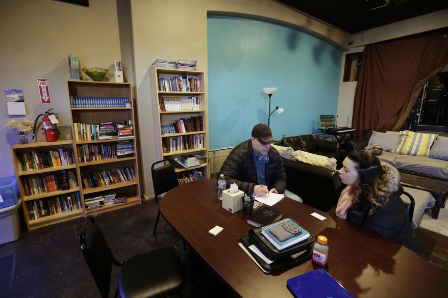 In this photo taken Feb. 27, 2017, Jessica Wolfe, right, talks about her life story as she sits at The Genesis Project, a drop-in center for victims of sex trafficking in SeaTac, Wash. with King County Sheriff's Deputy Andy Conner, left, who founded center. Wolfe, who was forced into sex trafficking shortly after her 19th birthday is now struggling to find housing and a job after background checks find her prostitution convictions, but a measure passed last week in the Washington state Senate could rewrite current law to make it easier for victims of trafficking to vacate prostitution convictions. (AP Photo/Ted S. Warren)