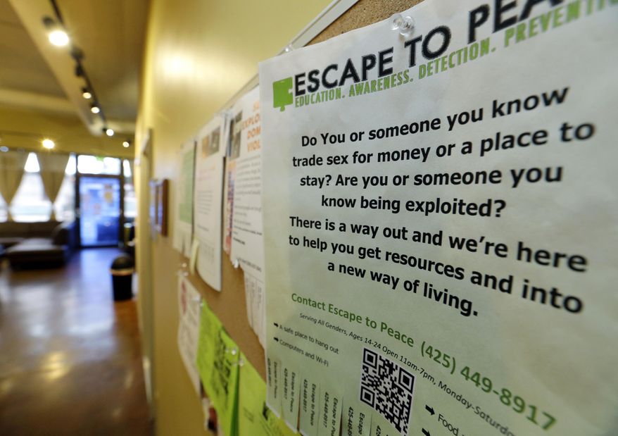 In this photo taken Feb. 27, 2017, a poster on the wall of The Genesis Project, a drop-in center for victims of sex trafficking in SeaTac, Wash., refers victims to a similar program at different location. A measure passed last week in the Washington state Senate could rewrite current law to make it easier for victims of trafficking to vacate prostitution convictions. (AP Photo/Ted S. Warren)