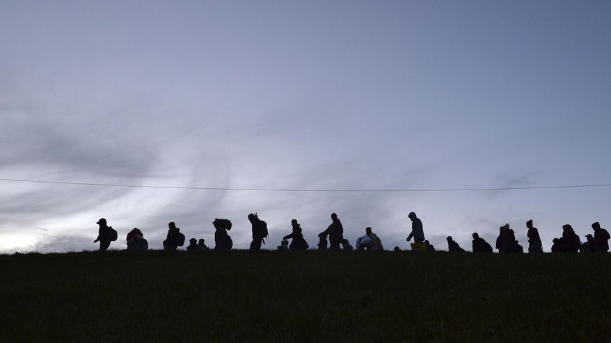 FILE - In this Oct. 28, 2015 file photo German federal police officers guide a group of migrants on their way after crossing the border between Austria and Germany in Wegscheid near Passau, Germany. German newspaper 'Welt am Sonntag' reports that the government planned to close the border with Austria and turn back asylum-seekers in September 2015, but nixed the plan at the last minute., the paper reported Sunday March 5, 2017. The interior ministry said in a statement it could “neither confirm nor deny” the report. (AP Photo/Kerstin Joensson,file)