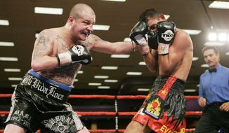 FILE - In this Feb. 23, 2007, file photo, five-time world champion Johnny Tapia, left, connects with Evaristo Primero in the ninth round of a 10-round junior welterweight bout at Isleta Pueblo, N.M. A court-ordered DNA test shows a man who has long claimed to be the father of the late boxing champ Tapia is not his dad after all, in the latest saga involving the troubled boxer after his death. The Albuquerque Journal reports Thursday, March 2, 2017, a copy of the test results obtained by the newspaper indicates conclusively that Jerry Padilla is not Tapia&#x27;s biological father. (AP Photo/Jake Schoellkopf, File)