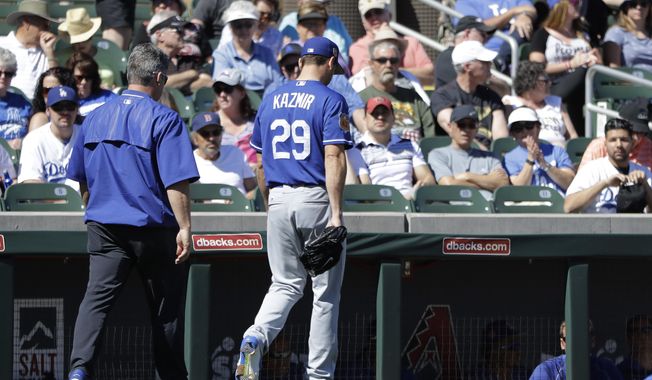 Los Angeles Dodgers' Scott Kazmir leaves with a trainer during the second inning of a spring training baseball game against the Colorado Rockies, Monday, March 6, 2017, in Scottsdale, Ariz. (AP Photo/Darron Cummings)