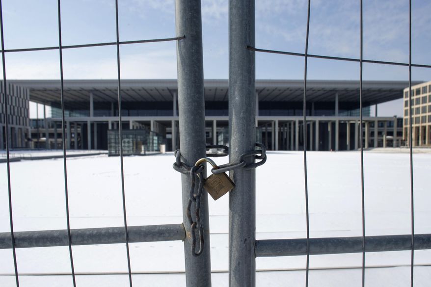 FILE - In this March 14, 2013 file photo, a fence shields the main terminal of the new Berlin Brandenburg International Airport named Willy-Brandt-Flughafen in Schoenefeld near Berlin. A member of Berlin’s state government, Engelbert Luetke Daldrup, on Monday took over the helm from Karsten Muehlenfeld who left the job prematurely after an endless series of cost overruns and technical and personnel problems that have led to ongoing delays in the opening of the new airport, which was initially touted as a national prestige project. (AP Photo/Markus Schreiber,file)