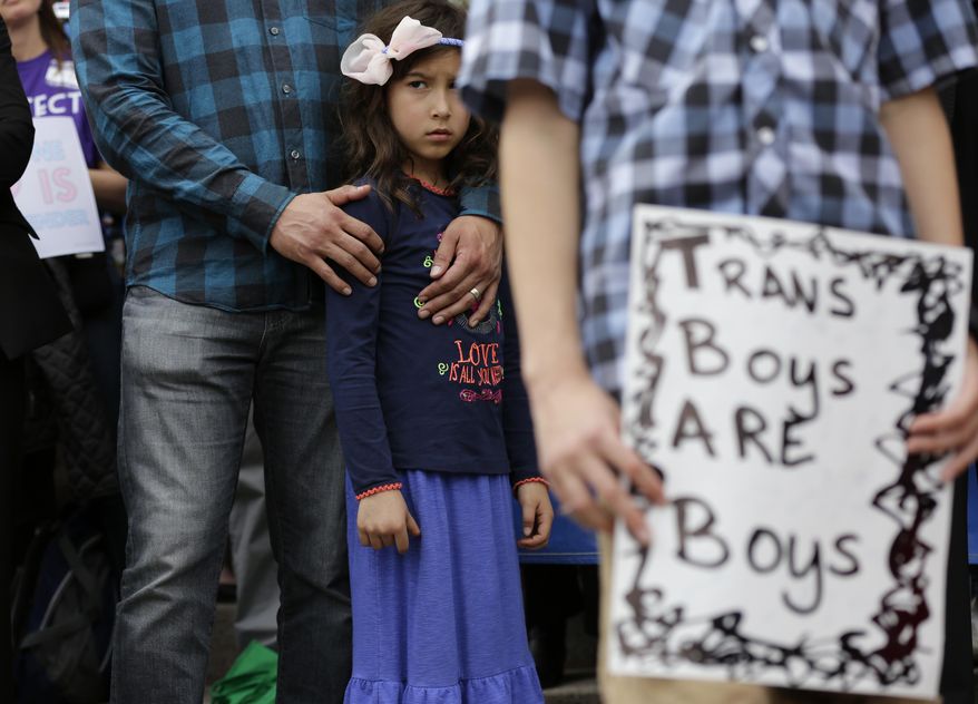 Libby Gonzales stands with her father, Frank Gonzales, as she joins other members of the transgender community during a rally on the steps of the Texas Capitol, Monday, March 6, 2017, in Austin, Texas. The group is opposing a "bathroom bill" that would require people to use public bathrooms and restrooms that correspond with the sex on their birth certificate. (AP Photo/Eric Gay)