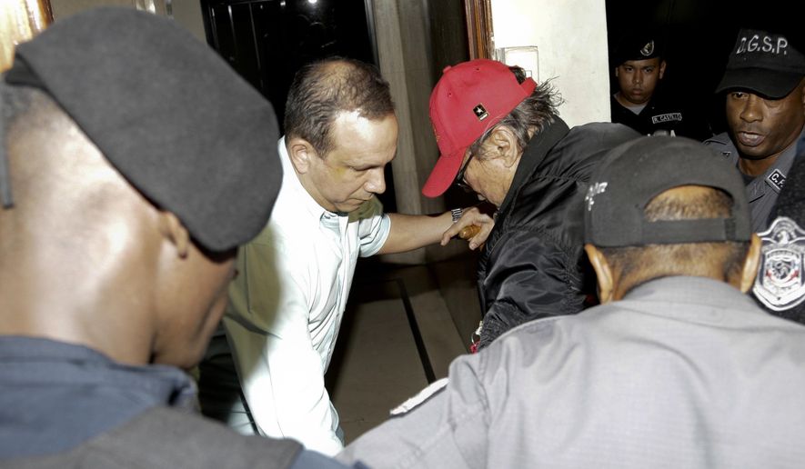 FILE - In this Jan. 28, 2017, file photo, Panamanian ex-dictator Manuel Antonio Noriega, wearing a red baseball cap, arrives after being placed under house arrest for three months in Panama City. Noriega has been hospitalized to undergo surgery to remove a benign tumor from his brain. Thays Noriega, one of his daughters, said surgery was scheduled for Tuesday, March 6. (AP Photo/Arnulfo Franco, File)