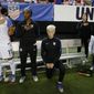 FILE - In this Sunday, Sept. 18, 2016 file photo, United States&#39; Megan Rapinoe, right, kneels next to teammates Ali Krieger (11) and Crystal Dunn (16) as the U.S. national anthem is played before an exhibition soccer match against Netherlands in Atlanta. Megan Rapinoe says she will respect a new U.S. Soccer Federation policy that says national team players &amp;quot;shall stand respectfully&amp;quot; during national anthems. The policy was approved last month but came to light Saturday, March 4, 2017 before the U.S. women&#39;s national team lost to England in a SheBelieves Cup match. (AP Photo/John Bazemore, File) **FILE**