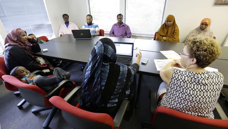 FILE - In this July 21, 2015 file photo, David Douglas High School board member Frida Christopher, right, talks with Somalian parents about the laws and rules of sending their children to school at the African Youth and Community Organization in East Portland, Ore. Somali immigrants in Oregon are reacting to President Trump's revised travel ban with dismay and fear. Musse Olal, president of Somali American Council of Oregon, said Monday, March, 6, 2017, that the ban is discriminatory and will further isolate Somali immigrants from American society by making them feel targeted. (AP Photo/Don Ryan, File)
