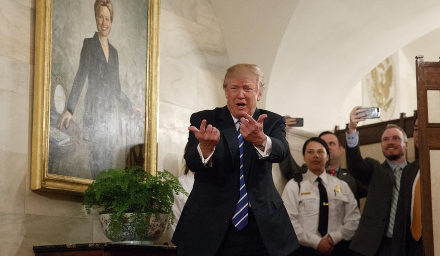 President Donald Trump greets visitors touring the White House in Washington, Tuesday, March 7, 2017. The president greeted the first wave of tourists to come through the White House since he assumed office, welcoming a small crowd of visitors in the East Wing, waving from behind a velvet rope as the crowd screamed, cheered and took photos. (AP Photo/Evan Vucci)