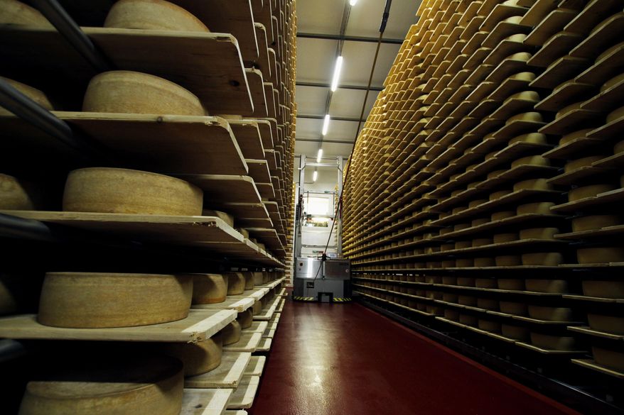 In this Feb. 27, 2017, photo, wheels of Grand Cru Surchoix cheese sit on spruce planks to age for nine months at the Emmi Roth USA production plant in Monroe, Wis. The company won the World Championship Cheese Contest in 2016 for the cheese and since then has seen an increase in sales of the cheese. The contest is organized by the Wisconsin Cheese Makers Association, which also organizes the United States Championship Cheese Contest that runs until March 9 in Green Bay, Wis. The contests are in alternate years. (AP Photo/Carrie Antlfinger)