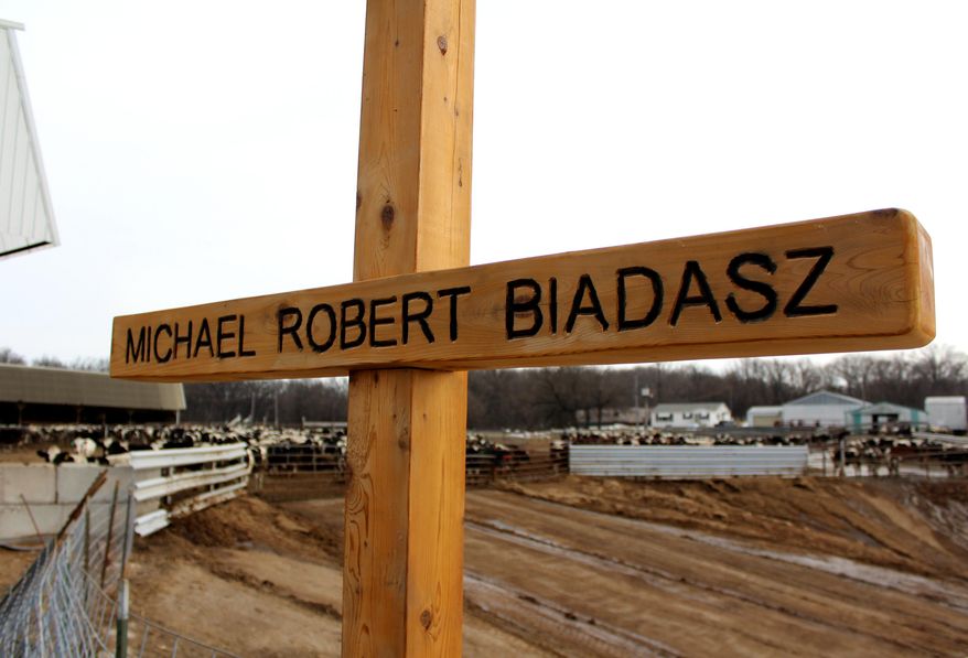 ADVANCE FOR MONDAY MARCH 13 AND THEREAFTER - An engraved wooden cross stands as a memorial near the spot where Mike Biadasz, 29, was found dead in August 2016 on his family&#39;s farm in Amherst, Wis., after he was overcome by gases from a manure pit. Bob and his wife, Diane, always expected Mike would someday take over the family farm. Now, the words he lived by can be read on a pair of signs placed on the farm: “Live today like you are going to die tomorrow, but farm today like you are going to farm forever.”  (Chris Mueller/The Stevens Point Journal via AP)