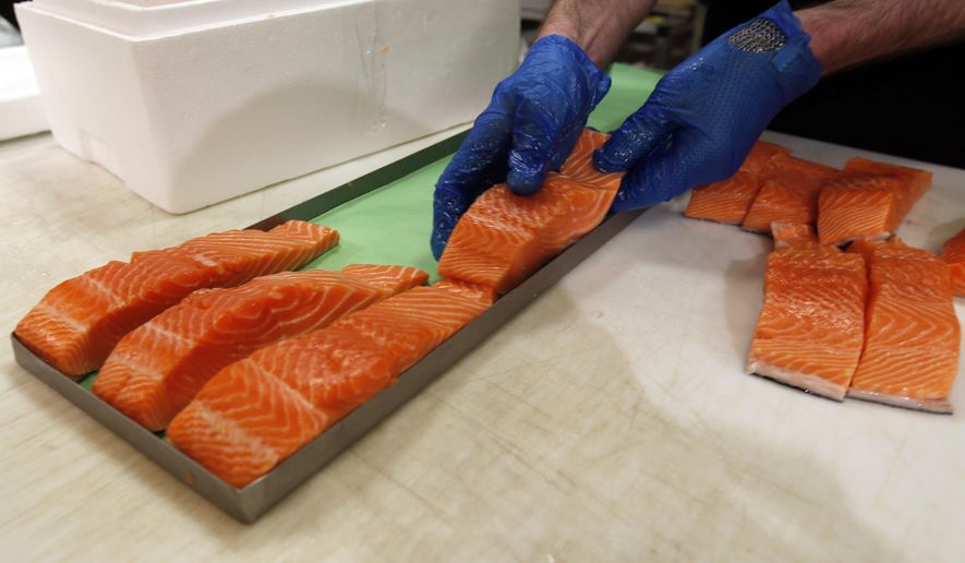In this Friday, April 10, 2015 photo, Canadian certified organic farm-raised King Salmon filets are placed on a tray in a store in Fairfax, Va. Overeating or under-eating 10 foods and nutrients contributes to nearly half of U.S. deaths from heart disease, strokes and diabetes, a study released on Tuesday, March 7, 2017, suggests. "Good" foods that were under-eaten include: nuts and seeds, seafood rich in omega-3 fats including salmon and sardines; fruits and vegetables; and whole grains. (AP Photo/Alex Brandon)