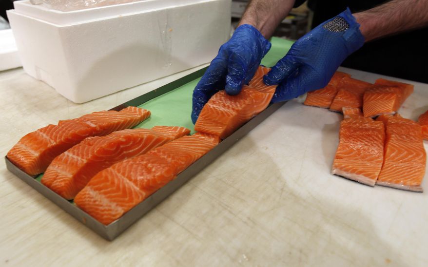 In this Friday, April 10, 2015 photo, Canadian certified organic farm-raised King Salmon filets are placed on a tray in a store in Fairfax, Va. Overeating or under-eating 10 foods and nutrients contributes to nearly half of U.S. deaths from heart disease, strokes and diabetes, a study released on Tuesday, March 7, 2017, suggests. "Good" foods that were under-eaten include: nuts and seeds, seafood rich in omega-3 fats including salmon and sardines; fruits and vegetables; and whole grains. (AP Photo/Alex Brandon)