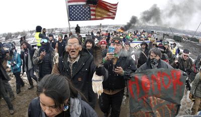 In this  Feb. 22, 2017, file photo, a large crowd representing a majority of the remaining Dakota Access Pipeline protesters march out of the Oceti Sakowin camp before the 2 p.m. local time deadline set for evacuation of the camp mandated by the U.S. Army Corps of Engineers near Cannon Ball, N.D. (Mike McCleary/The Bismarck Tribune via AP, File)