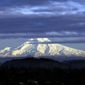 In this Nov. 29, 2016, photo, Oregon&#39;s Mount Hood, sporting a fresh coat of new snow, is lit through dispersing clouds by the setting sun as seen from Portland, Ore. (AP Photo/Don Ryan) **FILE**