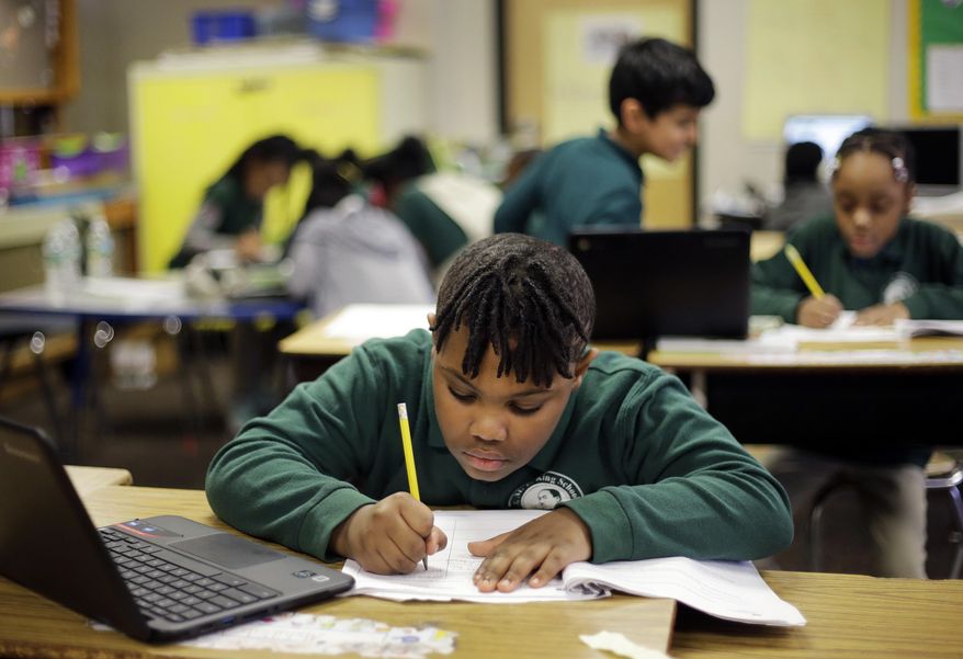 In this Feb. 23, 2017 photo, Justin Beckles works on a project in his third-grade classroom at the Martin Luther King Jr. Elementary School in Hartford, Conn. A proposal to shutter the hollowed-out, 1920s-era Gothic hilltop school building has only heightened a sense of neglect among many in the poor, largely African-American neighborhood. (AP Photo/Elise Amendola)