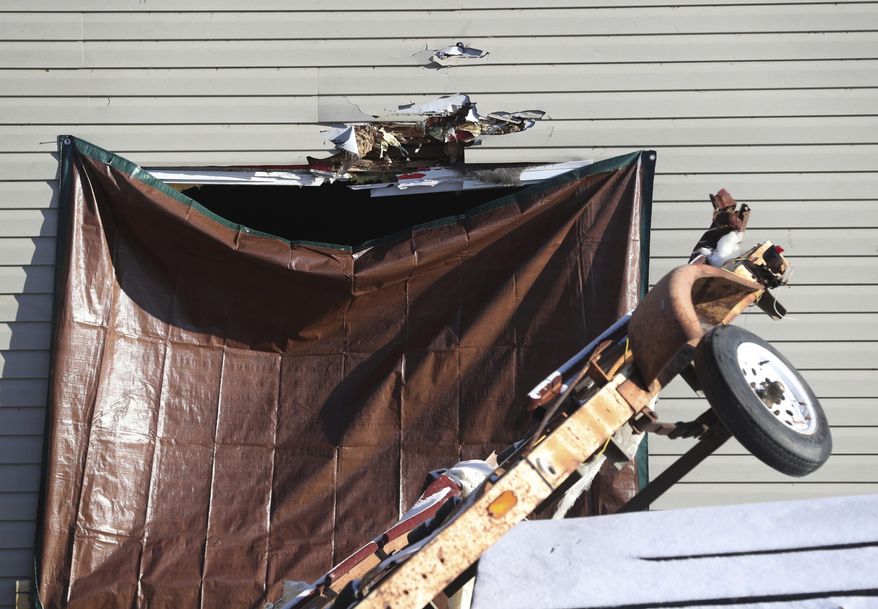 Damage from Monday's storm is shown to the side of a house near Ann Lake where a boat trailer had been tossed against it on Tuesday, March 7, 2017, in Orrock Township near Zimmerman, Minn. Weather experts say a likely tornado touched down northwest of the Twin Cities, taking down trees and power lines and damaging buildings. (David Joles /Star Tribune via AP)