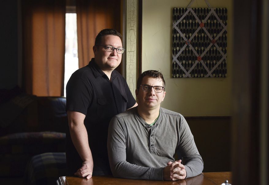In this Feb. 10, 2017 photo, Billy Mawhiney, left, and his husband, Kyle Margheim pose for a portrait in their home in Sioux Falls, S.D. The pair spent more than two years going through criminal background checks, submitting financial disclosure statements and attending parenting classes before they could become foster parents. A bill that would give new legal protections to adoption agencies and foster groups that cite religious reasons for denying services is one step away from becoming law in South Dakota. Critics say it would allow state-funded child-placement agencies to discriminate against children or prospective parents. (Jay Pickthorn/The Argus Leader via AP)