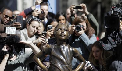 People stop to photograph the &amp;quot;Fearless Girl&amp;quot; statue, Wednesday, March 8, 2017, in New York. The statue was installed by investment firm State Street Global Advisors. An inscription at the base reads, &amp;quot;Know the power of women in leadership. She makes a difference.&amp;quot; (AP Photo/Mark Lennihan)