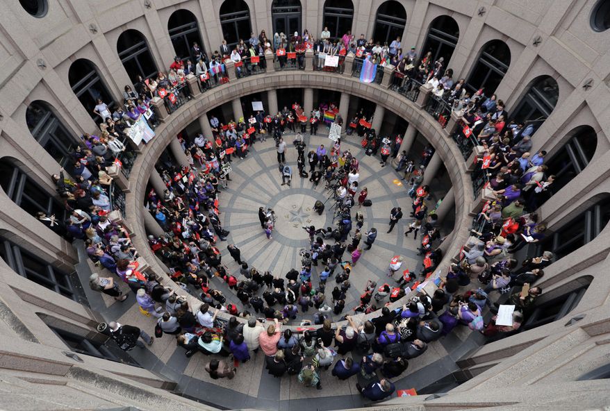 Members of the transgender community and others who oppose Senate Bill 6 protest in the exterior rotunda at the Texas state Capitol as the Senate State Affairs Committee holds hearings on the bill, Tuesday, March 7, 2017, in Austin, Texas. The the transgender "bathroom bill" would require people to use public bathrooms and restrooms that correspond with the sex on their birth certificate. (AP Photo/Eric Gay)
