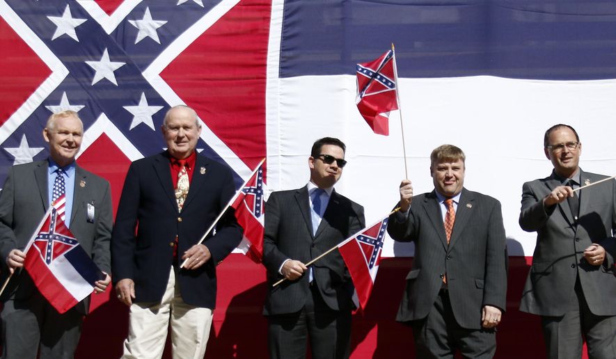 In this Jan. 16, 2016, file photo, a group of Mississippi flag supporting lawmakers, from left, Republican Reps. Robert Foster of Hernando, Dana Criswell of Olive Branch, Ken Morgan of Morgantown, Chris Brown of Nettleton, Bubba Carpenter of Burnsville and William Shirley of Quitman., pose in front of a large Mississippi state flag on the south steps of the Capitol in Jackson, Miss., during a rally sponsored by the Sons of Confederate Veterans and other groups in support of keeping the Confederate battle emblem on the state flag. Shirley wrote and presented a flag amendment attached to a universities finance bill that would withhold proposed tax exemptions to public universities that refuse to fly the state flag. (AP Photo/Rogelio V. Solis)