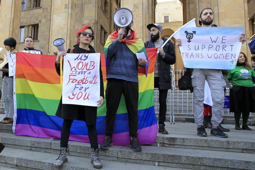 Young people hold posters in support of gay rights during a rally to mark International Women's Day in Tbilisi, Georgia, Wednesday, March 8, 2017. Women around the globe are taking to the streets to mark the day. (AP Photo/Shakh Aivazov)