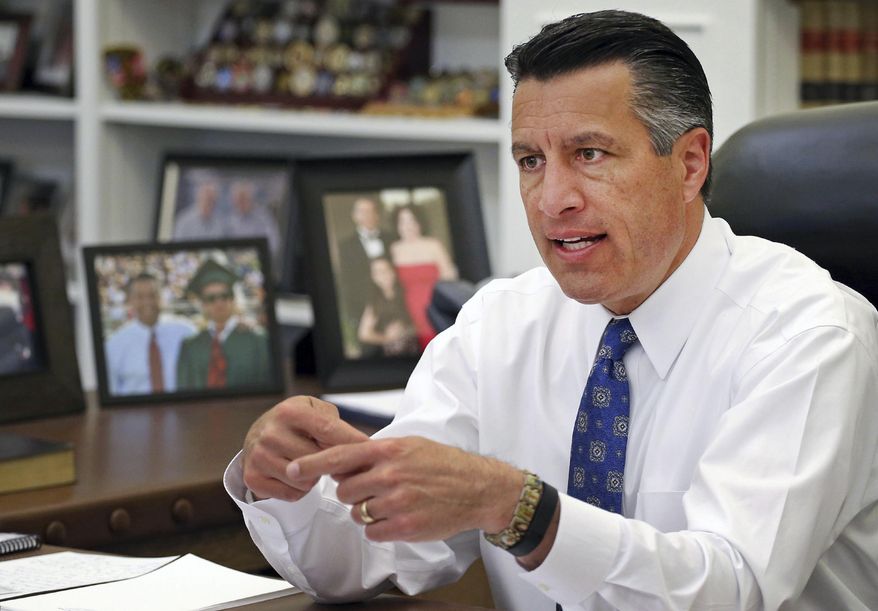 FILE - In this April 17, 2015, file photo, Nevada Gov. Brian Sandoval sits in his office at the Capitol in Carson City, Nev. Mirroring concerns raised by Democrats, Republican governors including Sandoval complain that the proposal from the GOP-controlled U.S. House to replace the existing health care law would force millions of lower-income earners from insurance rolls or stick states with the cost of keeping them covered. (AP Photo/Cathleen Allison, File)