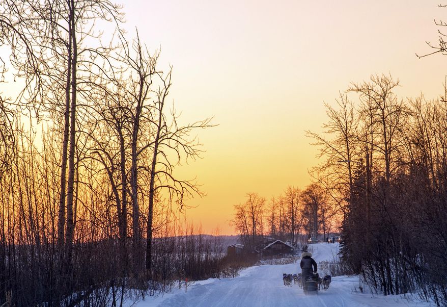 In this image taken Tuesday, March 7, 2017, and provided by the Iditarod Trail Committee, the sun sets as veteran musher Nicolas Petit makes his way into Tanana, Alaska, the third checkpoint of the Iditarod Trail Sled Dog Race. (Mike Kenney/Iditarod Trail Committee via AP)