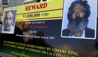 FILE- In this Tuesday, March 6, 2012 file photo, an FBI poster showing a composite image of former FBI agent Robert Levinson, right, of how he would look like now after five years in captivity, and an image, left, taken from the video, released by his kidnappers, in Washington during a news conference. It’s been 10 years since former FBI agent Robert Levinson disappeared while in Iran on an unauthorized CIA mission and his family is still waiting for answers. His family tells The Associated Press they hope the new administration of President Donald Trump will do more to find him. (AP Photo/Manuel Balce Ceneta, File)