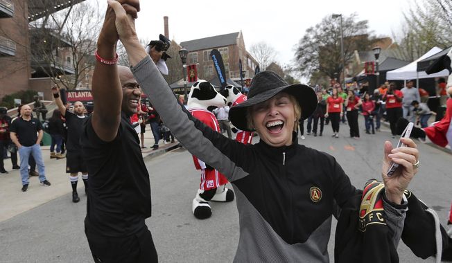This March 5, 2017 photo shows Atlanta United RC fan Barbara Morningstar dancing with MC Leighton outside Bobby Dodd Stadium before the first game in franchise history against the New York Red Bull in Atlanta. After the opening weekend of Major League Soccer, it looks as though Atlanta is doing everything right. Now all the team needs a first victory. It could come Sunday, March 12, 2017 against the league&#x27;s other expansion team and another United, Minnesota, at TCF Bank Stadium in Minneapolis. (Curtis Compton/Atlanta Journal-Constitution via AP)