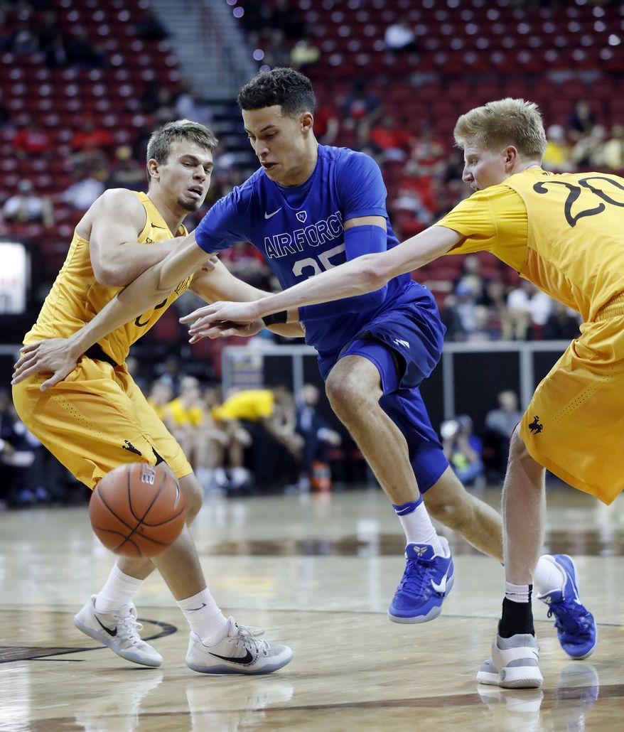 Air Force&#39;s Hayden Graham drives to the basket as Wyoming&#39;s Cody Kelley, left, and Hayden Dalton defend during the second half of an NCAA college basketball game in the Mountain West Conference tournament Wednesday, March 8, 2017, in Las Vegas. Air Force defeated Wyoming 83-68. (AP Photo/Isaac Brekken)