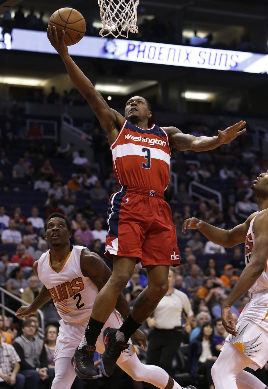 Washington Wizards guard Bradley Beal (3) drives past Phoenix Suns guard Eric Bledsoe (2) in the second quarter during an NBA basketball game, Tuesday, March 7, 2017, in Phoenix. (AP Photo/Rick Scuteri)