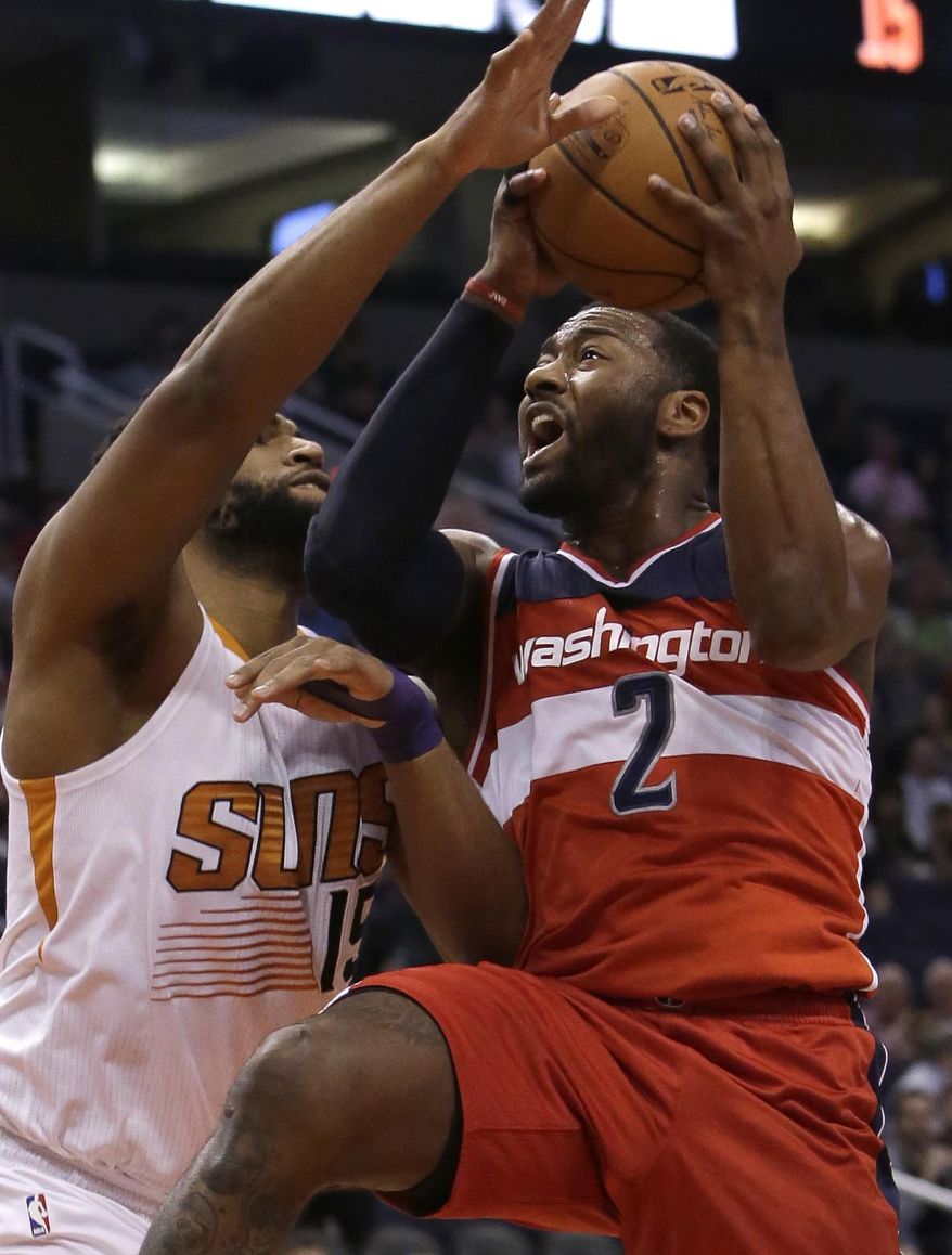 Washington Wizards guard John Wall (2) draws the foul from Phoenix Suns forward Alan Williams in the first quarter during an NBA basketball game, Tuesday, March 7, 2017, in Phoenix. (AP Photo/Rick Scuteri)