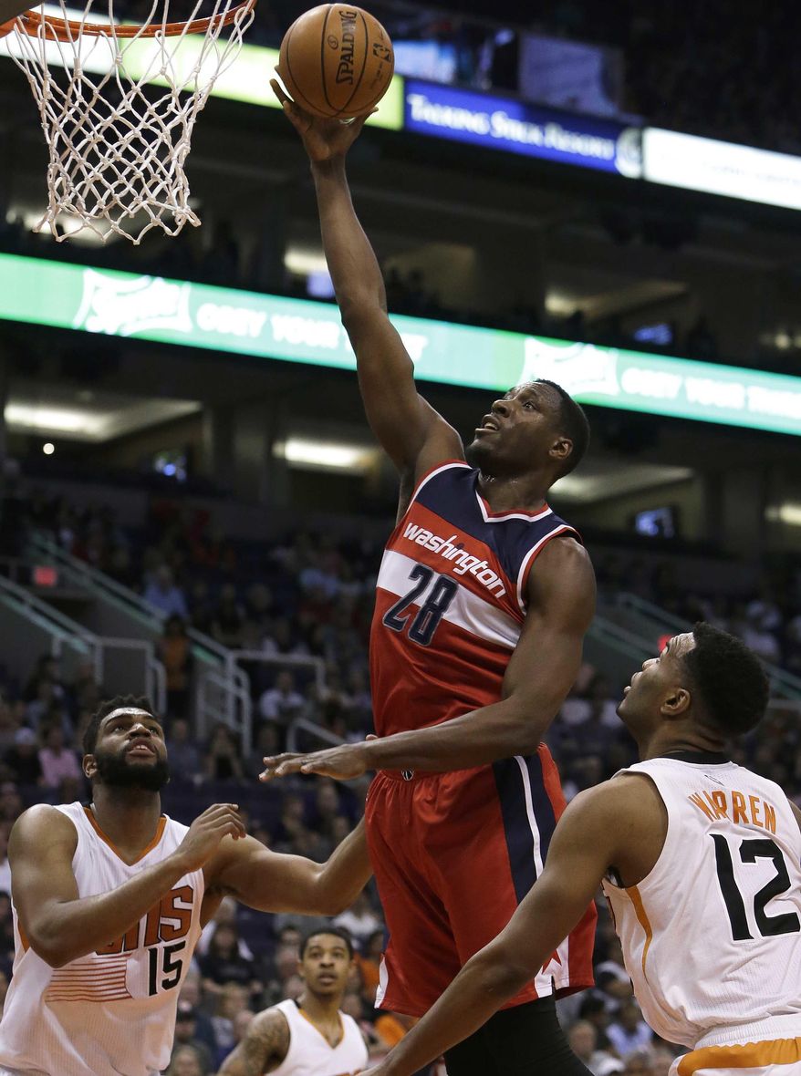 Washington Wizards center Ian Mahinmi (28) drives between Phoenix Suns forward Alan Williams (15) and TJ Warren (12) in the first quarter during an NBA basketball game, Tuesday, March 7, 2017, in Phoenix. (AP Photo/Rick Scuteri)