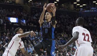 Duke forward Jayson Tatum (0) goes to the basket agains Louisville forward Deng Adel (22) and Ray Spalding (13) during the first half of an NCAA college basketball game in the Atlantic Coast Conference tournament, Thursday, March 9, 2017, in New York. (AP Photo/Mary Altaffer)