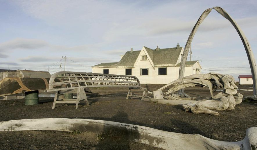 FILE - In this Aug. 12, 2005, file photo. a skin boat display sits next to whale bones and an arch made of a whale jaw on the beach at Brower's Cafe in Barrow, Alaska. A court hearing is set for Thursday, March 9, 2017, in Alaska for the two sides in a lawsuit challenging the new Inupiat Eskimo name of the nation's northernmost town. Voters in the town formerly known as Barrow approved the new name, Utqiagvik, by six votes last October. (AP Photo/Al Grillo, File)