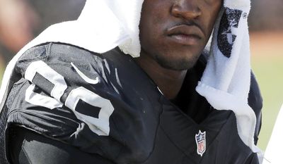 FILE - In this Sept. 20, 2015, file photo, Oakland Raiders defensive end Aldon Smith cools off during an NFL football game against the Baltimore Ravens in Oakland , Calif. Authorities say the suspended Raiders player was detained in San Francisco on Thursday morning, March 9, 2017. after an SUV he was a passenger in collided with an undercover San Francisco police car, injuring two officers. Smith was detained for public intoxication. (AP Photo/Tony Avelar, File)