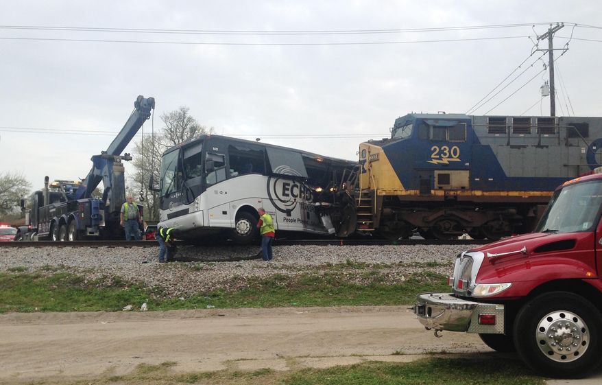 Men prepare to move a charter bus after a freight train crashed into the bus in Biloxi, Miss., Tuesday, March 7, 2017. The freight train smashed into the charter bus in the coastal Mississippi city on Tuesday, pushing the bus 300 feet down the tracks and leaving several people dead, authorities said. (AP Photo/Kevin McGill)