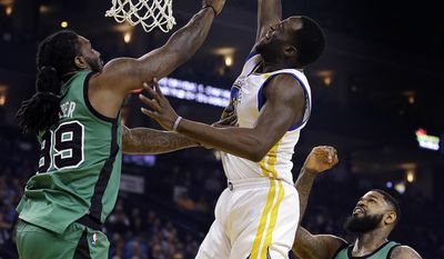 Golden State Warriors&#39; Draymond Green, center, shoots over Boston Celtics&#39; Jae Crowder, left, and Amir Johnson, right, during the first half of an NBA basketball game Wednesday, March 8, 2017, in Oakland, Calif. (AP Photo/Ben Margot)
